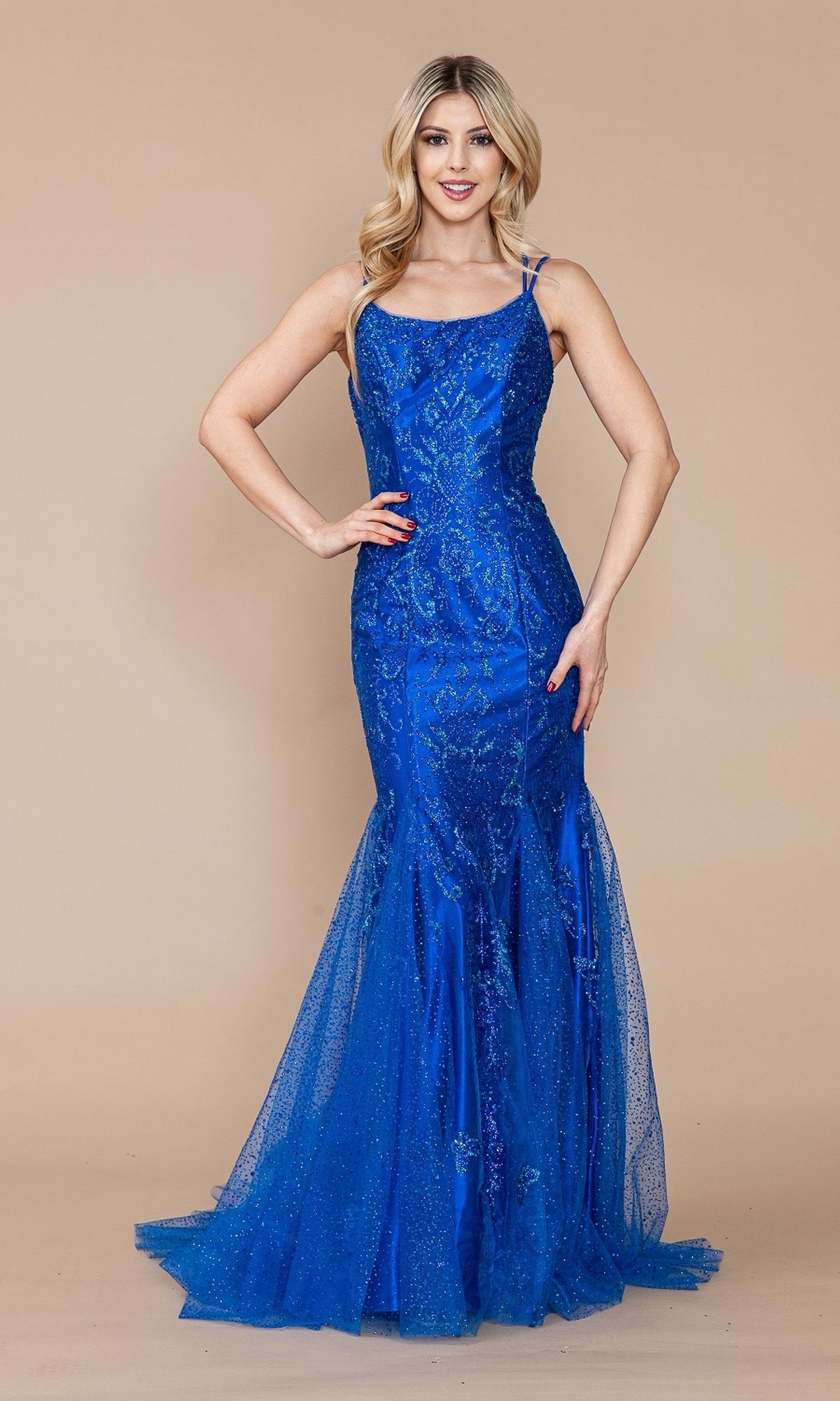 A woman models the Glitter-Print Long Mermaid Prom Dress 9306, featuring a fitted, floor-length bright blue silhouette with sequin details and a corset back, set against a plain beige background.